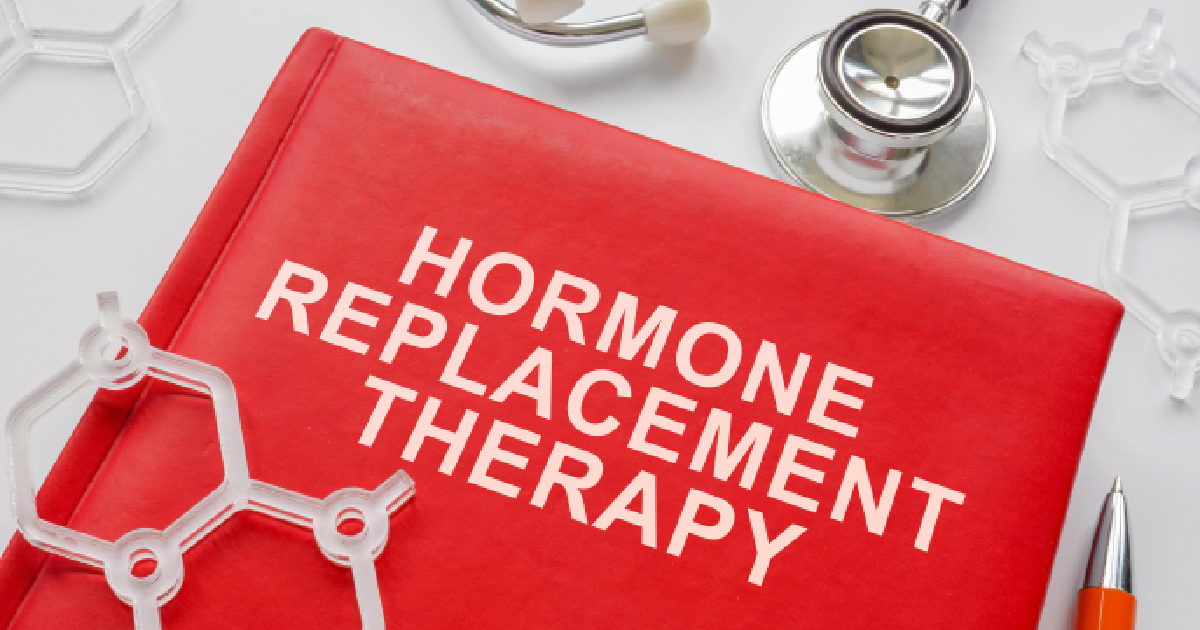 Red book titled 'HORMONE REPLACEMENT THERAPY (HRT) in Scottsdale, AZ' on a white surface with a stethoscope, pen, and molecular models